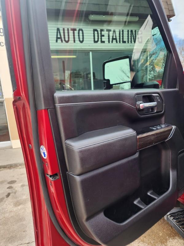 A red truck with the door open and its side panel opened.