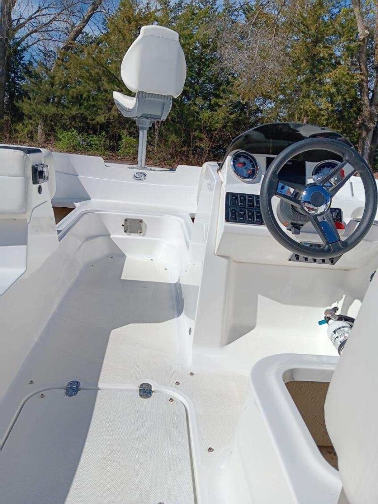 A boat with the steering wheel and seat in the back.