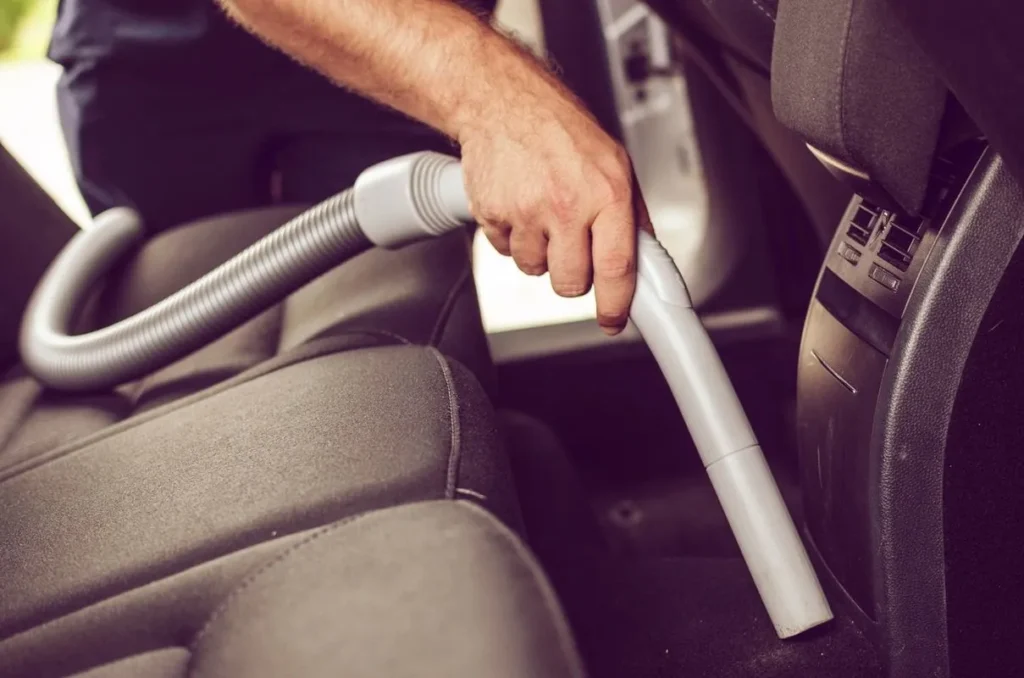 Vacuuming the interior of a car.