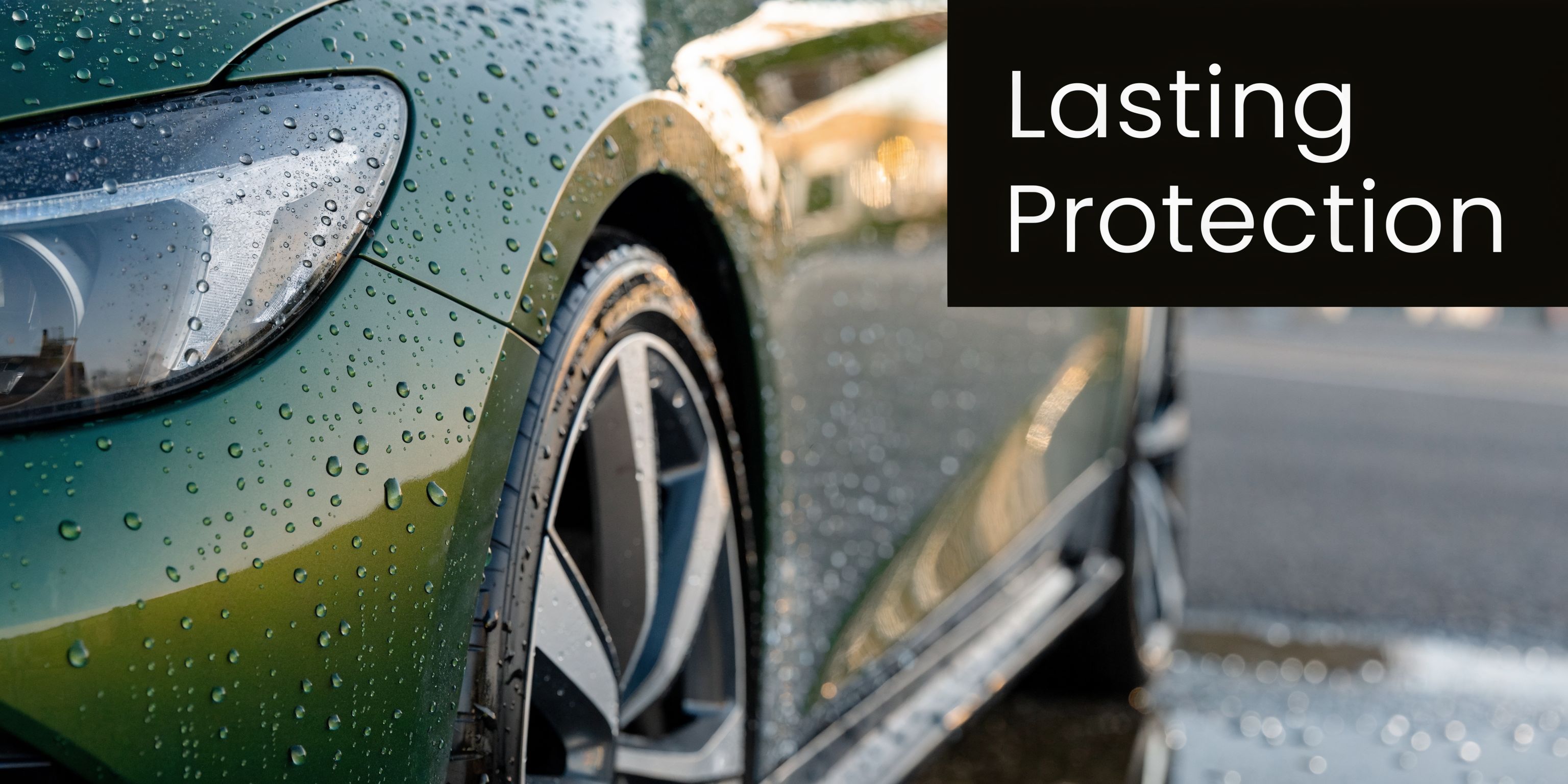 A close-up view of a green car covered in raindrops after a professional automotive detailing service.