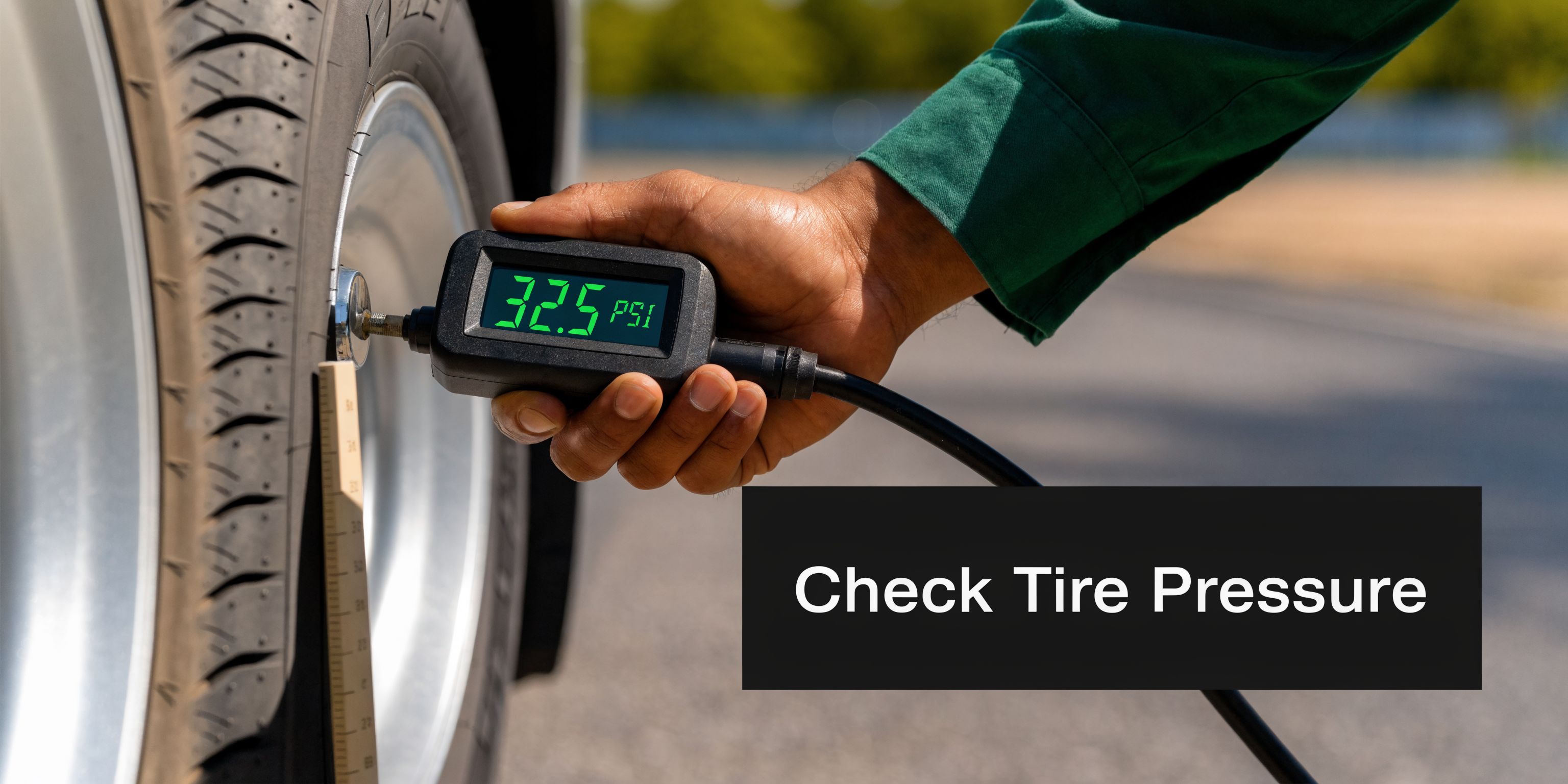A technician using a digital gauge to check the tire pressure on a fleet vehicle wheel.