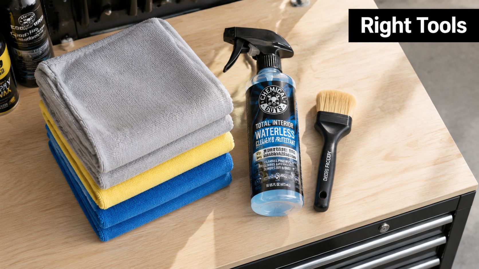 A stack of colorful microfiber towels, a spray bottle of cleaner, and a brush on a workbench.