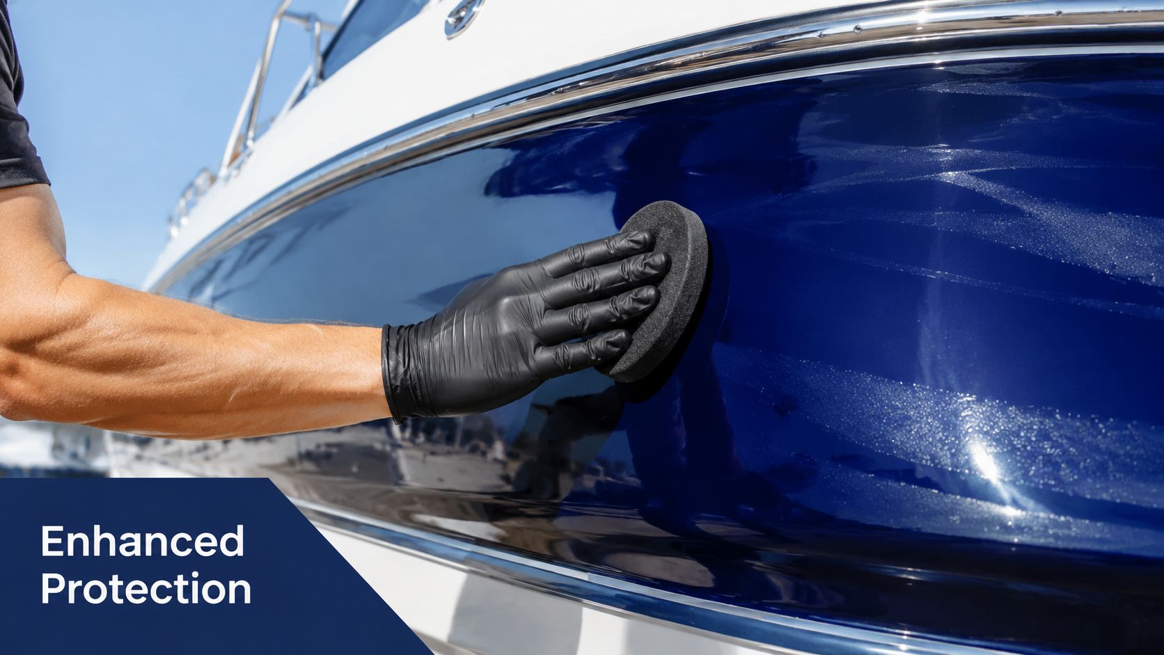 A gloved hand uses a foam applicator to apply protective wax to a blue boat hull.